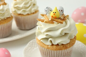 Tasty Easter cupcakes with vanilla cream on white table, closeup