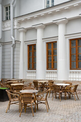 A cozy outdoor cafe with elegant wicker furniture against the background of an ancient building