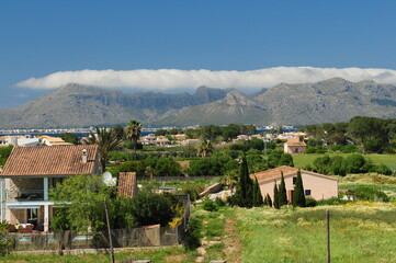 Fototapeta na wymiar View From Alcudia To The Cloudy Tramuntana Mountains Mallorca On A Wonderful Sunny Spring Day With A Clear Blue Sky