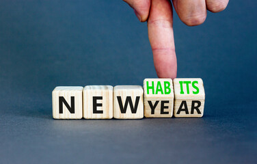 New year and habits symbol. Concept word New year New habits on wooden cubes. Beautiful grey table grey background. Psychologist hand. Psychological new year and habits concept. Copy space.