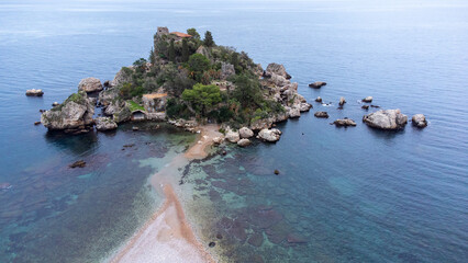 Panoramic view of beautiful Isola Bella, small island near Taormina, Sicily, Italy. Narrow path connects island to mainland Taormina beach surrounded by azure waters of Ionian Sea. - 770872336
