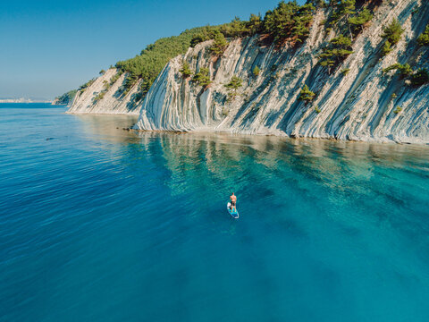 Paddle Boarding In Mediterranean Sea With Mountain Coastline. Aerial Drone View