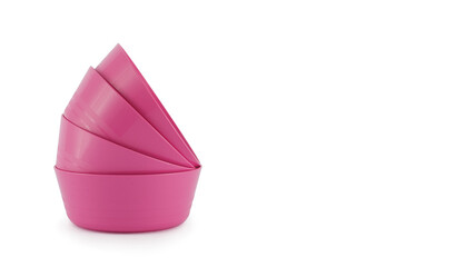 Stack of reusable pink plastic bowls, colourful and bright, graphic prawn shape isolated on white background. Concept of fun children’s food, eco-friendly parties and picnics, reusable tableware.