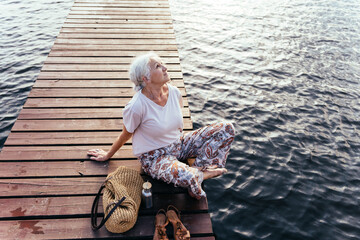 Senior aged woman feeling freedom,enjoying vacation. No stress,calm mind,relax, happy retirement, healthy lifestyle, outdoor portrait. - obrazy, fototapety, plakaty