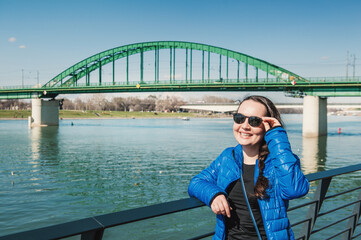 Beautiful happy woman with sunglasses against bridge in Belgrade, Serbia