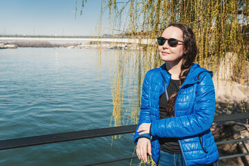 Beautiful woman with sunglasses against Sava river in Belgrade, Serbia