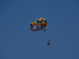 paragliding in the blue sky sunny day in barcelona full shot low angle