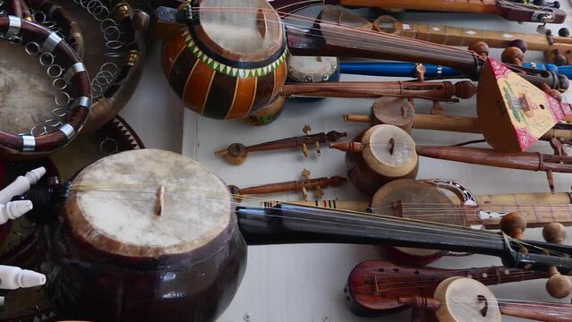 Vertical video footage of a shop with musical instruments on the street of the city of Bukhara. Uzbekistan. Trade in souvenirs in Central Asia.