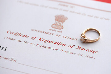 Indian Certificate of registration of marriage blank document and wedding ring on table close up