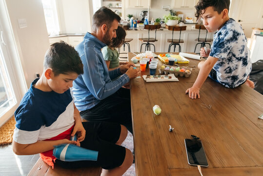 A dining room table messy with Easter egg decorations. 