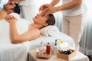 Caucasian couple enjoying relaxing anti-stress head massage and pampering facial beauty skin...