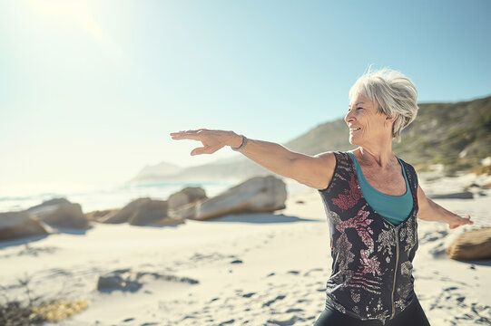 Active Senior Woman Doing Yoga on Beach