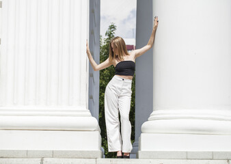 Portrait of a young beautiful blonde model in white trousers © Andrey_Arkusha
