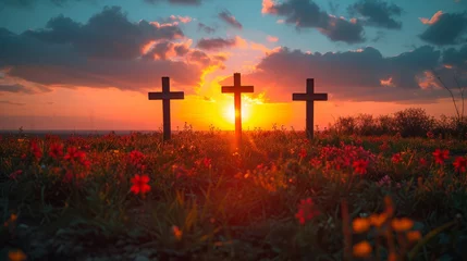 Foto op Plexiglas   A pair of crosses in a flower-filled field at sunset, with the sun sinking behind them © Wall