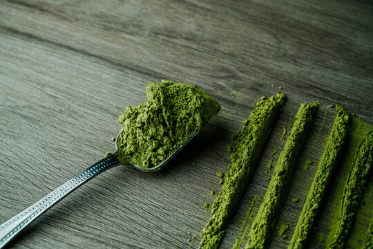 lines of matcha powder tea and spoon with matcha