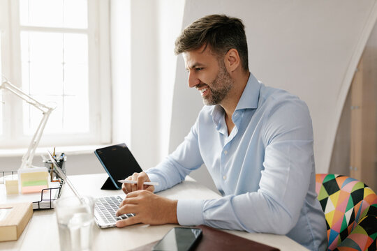 Happy Middle age businessman using laptop in the office 