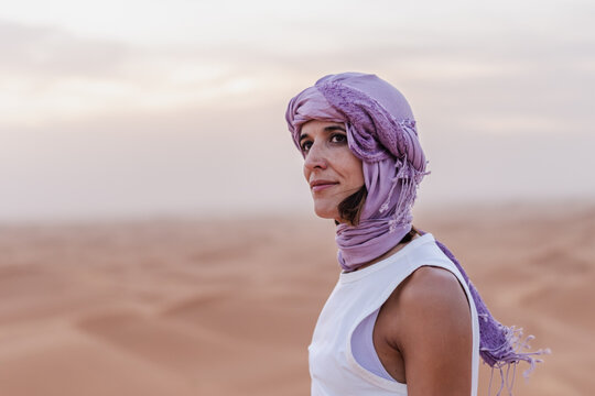 Smiling Woman in Desert Wearing Traditional Turban