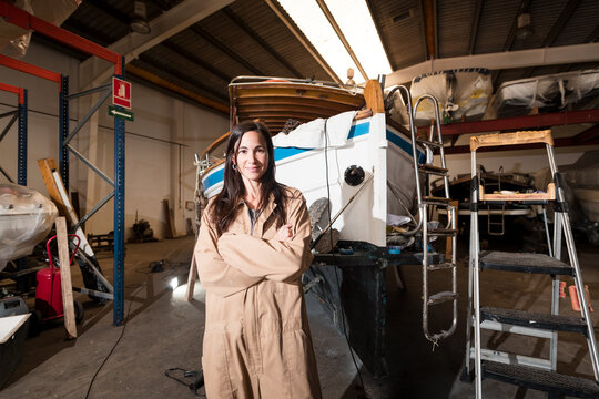 Proud female boat mechanic at workshop