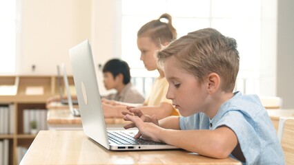 Caucasian smart child programing software system and learning about coding while multicultural...