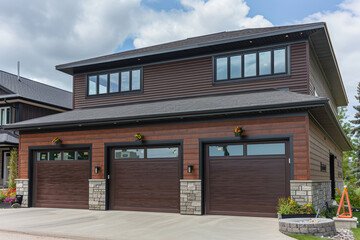 Opulent and contemporary home, freshly constructed, with a two-car garage, wrapped in a rich chocolate brown siding and complemented by natural stone wall trim.