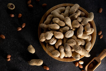 Dried peanuts in a shell in a wooden plate