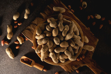 Dried peanuts in a shell in a wooden plate