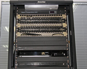 A telecommunications rack with multimedia and network electronic equipment.
