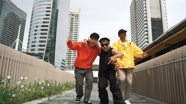 Group of handsome hipster standing while looking at camera with city view. Professional break dancer wear stylish cloth while moving or waving hands to hip hop music. Modern lifestyle. Sprightly.