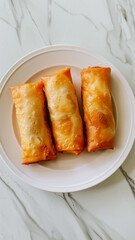 top view of a white plate with spring rolls 