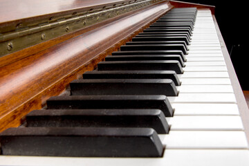 a close up angle view of all of the keys on a  rosewood piano keyboard