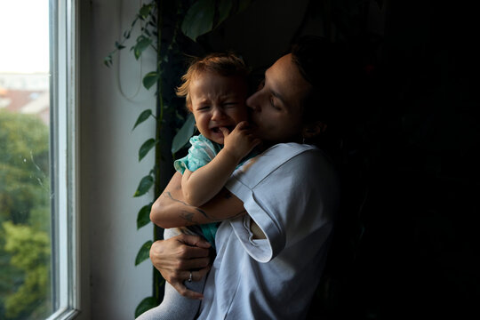 Mother kisses her crying son
