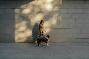Unrecognizable woman walking with pet dog on street