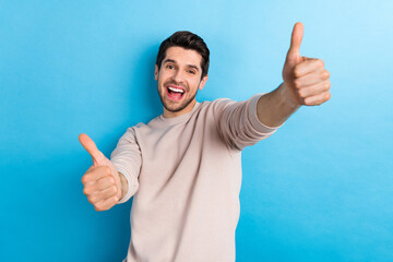 Photo of cheerful friendly guy with stylish hairstyle dressed white pullover showing thumb up good...