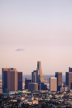A plane flying over Los Angeles at sunset
