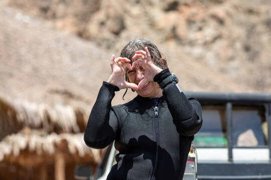 Woman joyfully gesturing a heart with her hands