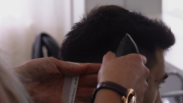 Close up of woman hand training to do a machine haircut on the hairdressing courses