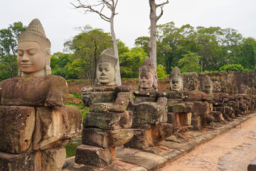 Fototapeta premium Angkor Thom - Churning of the Ocean Hindu mythology scene featuring rows of Gods and Demons on the causeway leading to Bayon temple at Siem Reap, Cambodia, Asia