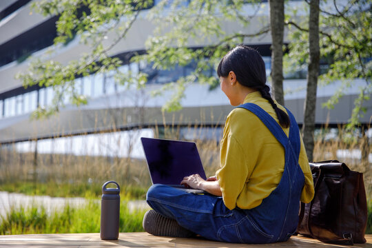 Student using laptop while analysing project at university campus