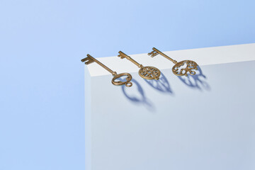 Trio of decorative antique keys lying on top of decorative white stand