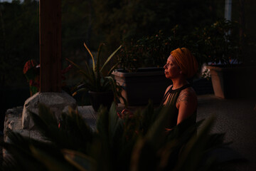 Relaxed woman with headscarf meditating outdoors