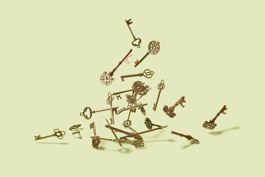 Pile of classical old house keys levitating over pastel background