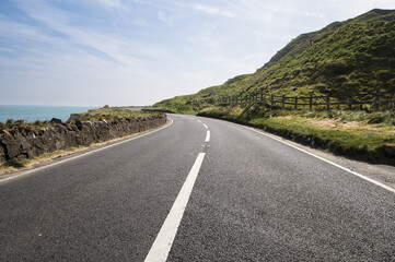 Empty road next to sea in County Antrim, Northern Ireland