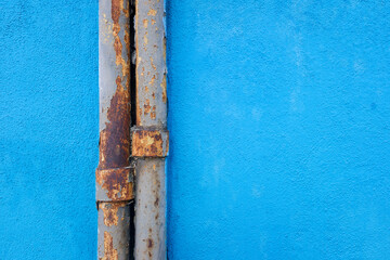 Rusty pipes on painted blue wall background