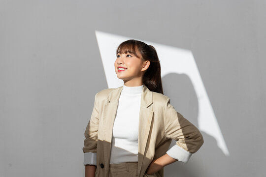 Young, beautiful woman in the modern suit under summer street shadow.