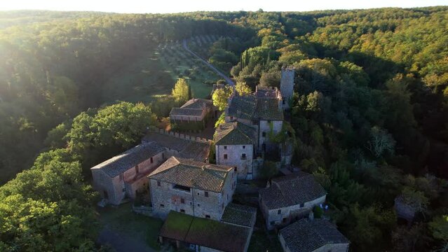 The castle and medieval village of Montalto in Chianti, Italy,  known as ‘la Berardenga’. aerial drone video on the sunrise. Scenic Italian landscape