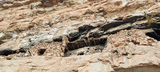 The balconies of Ghoufi, ancient Berber village, with stone and clay houses, carved into waterfalls in the rock, and the river which waters the oasis of palm trees and fruit trees. Batna. Algeria
