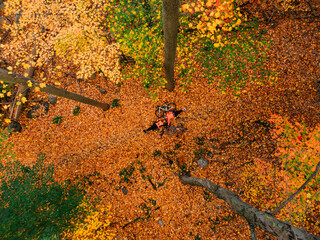 Couple with bicycles posing on the fallen leaves in an autumn forrest