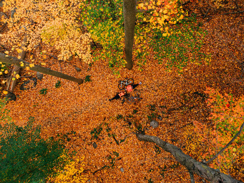 Couple of cyclists posing on the fallen leaves in an autumn forrest