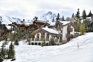 ski resort with chalets on the slopes in French alps.