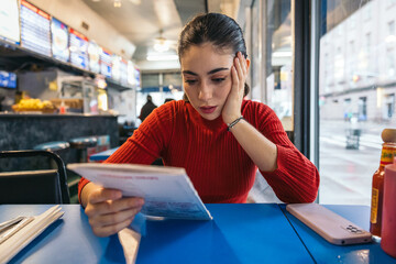 Woman reading the menu at a breakfast spot